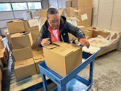 Sunshine Division Volunteer Handles Food Box